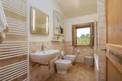 um banheiro com uma pia, um vaso sanitário e uma janela em CASALE LA CASCINA 8, Emma Villas em Force