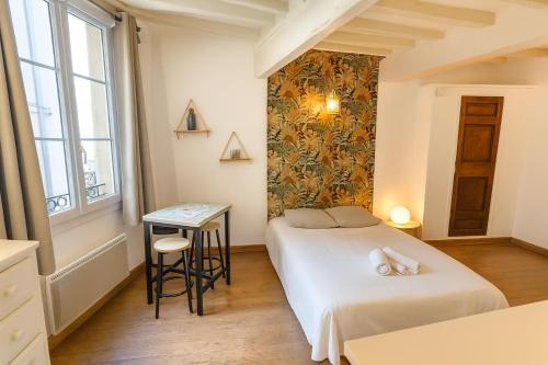 a room with two beds and a table in it at Le Papassaudi by La Familia in Aix-en-Provence