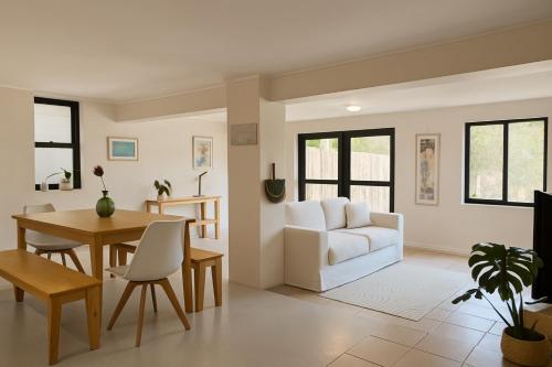 a living room with a white couch and a table at Wildlife and Ocean Cottage in Scarborough