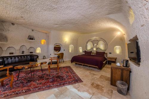 Un dormitorio con una cama, un sofá y una mesa. en Rose Moon Cave, en Nevşehir