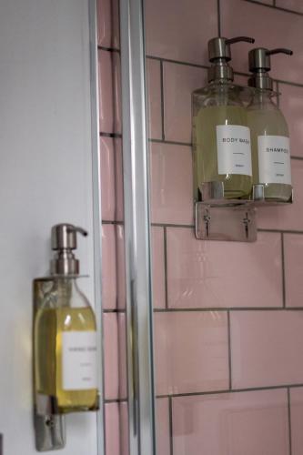 a bathroom with two bottles of soap on a wall at Island View in Campbeltown
