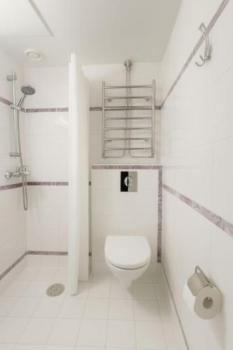 a white bathroom with a toilet and a shower at Arkadia Hotelli in Helsinki