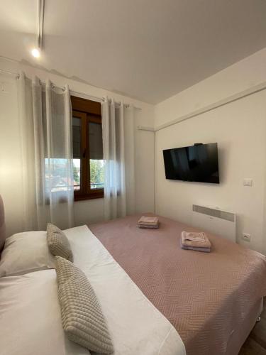 a bedroom with a large bed with a tv on the wall at Apartman A&N Zlatibor in Zlatibor