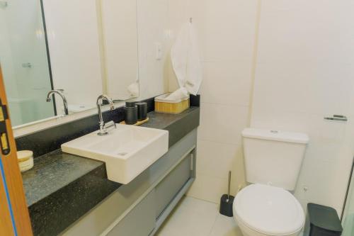een badkamer met een wit toilet en een wastafel bij Studio completo, Piscina, Wi-Fi e Garagem in Três Corações