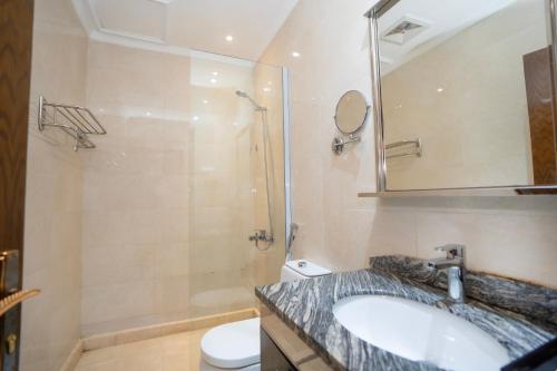 a bathroom with a sink and a shower and a toilet at فندق جوهرة المقام الحمراء in Jeddah