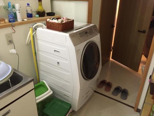 a washing machine with a basket on top of it in a kitchen at Farm&Inn Imodango Mura in Abashiri