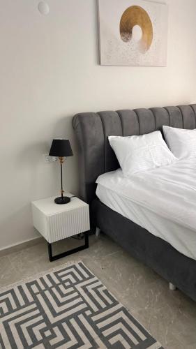 a bedroom with a bed and a table with a lamp at Rıversıdelıfe Iskele 164 in Vuda