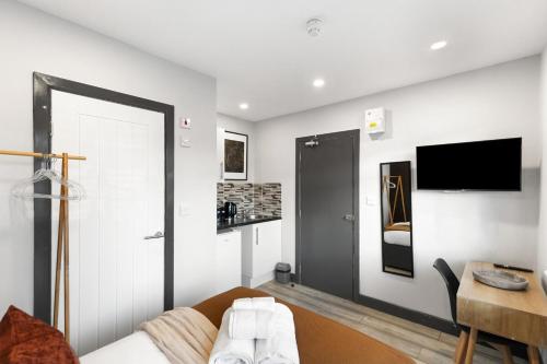 a living room with a couch and a tv at Comfy Room and Parking Fast Access to Central London in Perivale