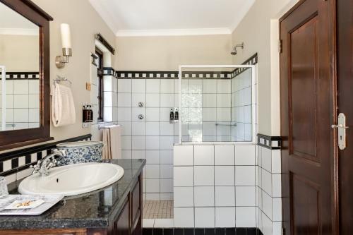 um banheiro com pia e chuveiro em Perry's Bridge Hollow Boutique Hotel em Hazyview