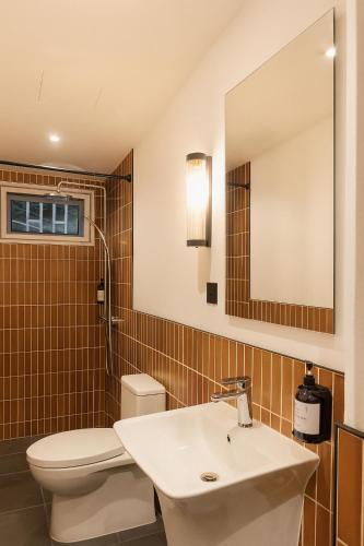 a bathroom with a sink and a toilet and a mirror at Busaba Ayutthaya Hotel in Phra Nakhon Si Ayutthaya