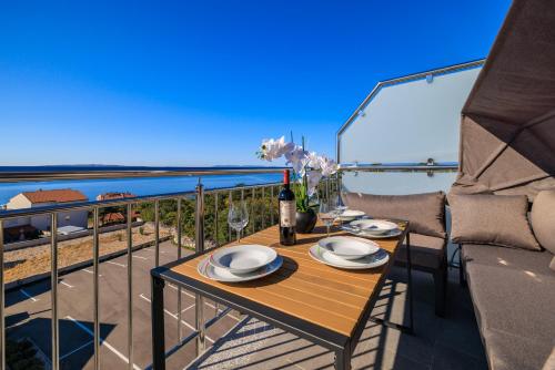ein Tisch mit einer Flasche Wein auf einem Balkon in der Unterkunft Apartments Sunshine E in Crikvenica