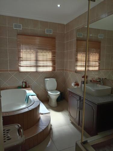 a bathroom with a tub and a sink and a toilet at Bluebird guest house in Kingsborough