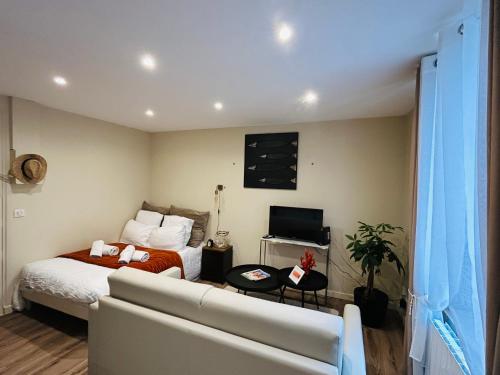 a bedroom with a bed and a couch and a tv at Le Studio, parking & accès Plage ! in Trouville-sur-Mer