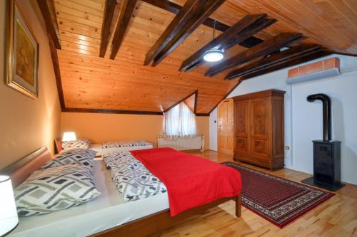 a bedroom with a large bed and a wooden ceiling at Villa Requiem in Bednja