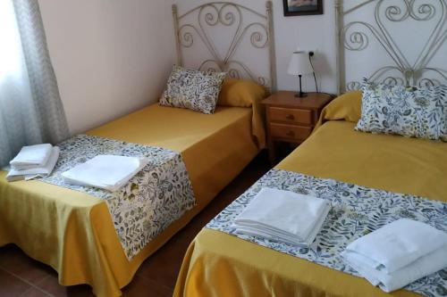 a bedroom with two beds with towels on them at Chalet Chaparrillo Conil Rentals in Conil de la Frontera