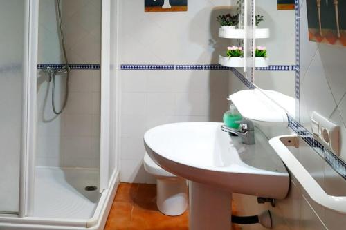 a white bathroom with a sink and a shower at Chalet Chaparrillo Conil Rentals in Conil de la Frontera