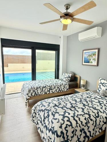 een slaapkamer met twee bedden en een plafondventilator bij Interni Villa by A&D Properties in Porto Rafti