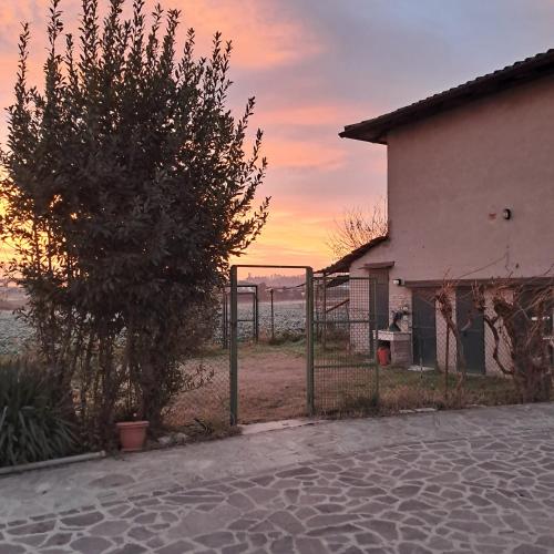 una recinzione di fronte a una casa con un albero di B&B La Magnolia a Arena Po