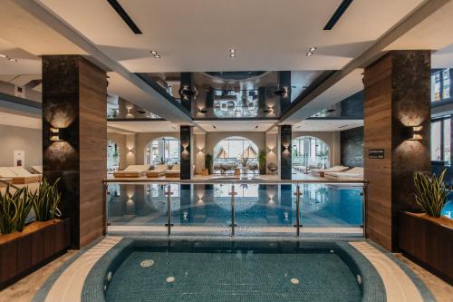 einen Pool in einer Hotellobby mit Pool in der Unterkunft Ведмежа гора Panorama Spa Resort in Jaremtsche