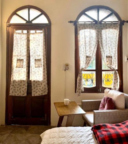 a room with two windows and a bed and a table at Hà Nội Mái Hiên Home in Hanoi