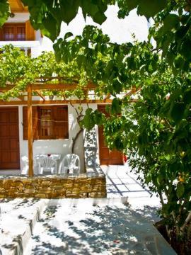 a house with a patio with chairs and a tree at Village Twins 1 in Ios Chora