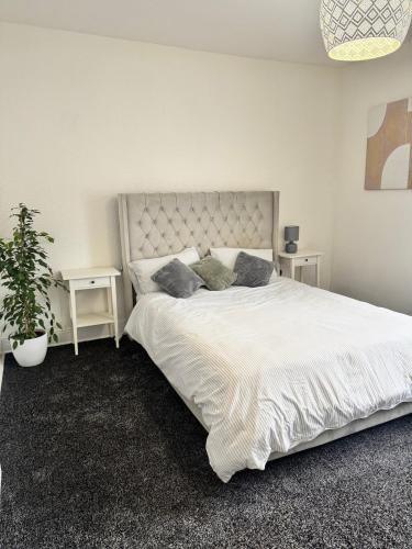 a bedroom with a large white bed with two pillows at Holgate Cottage in Great Harwood