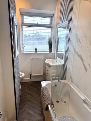 a bathroom with a tub and a sink and a toilet at Holgate Cottage in Great Harwood