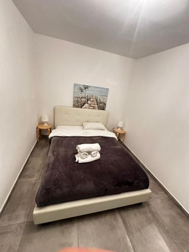 una camera da letto con un letto grande con una coperta nera di ARSENIa COTTAGE a Kyperounda