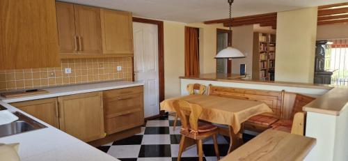 een keuken met een tafel en stoelen in een kamer bij Erdőalja-Padlástér in Jásd