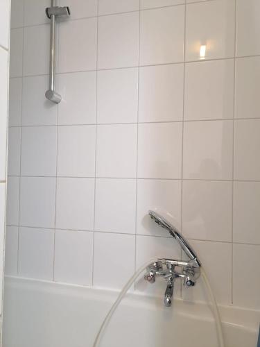 a bath tub with a shower head and a sink at De Peperbus in Lokeren