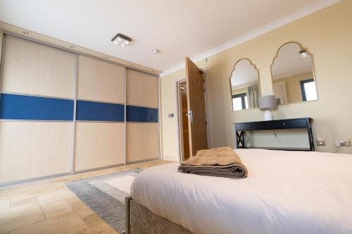 a bedroom with a large bed and a mirror at Stunning Swansea Marina beach house with sea views in Swansea