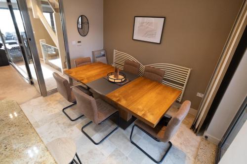 a dining room with a wooden table and chairs at Stunning Swansea Marina beach house with sea views in Swansea