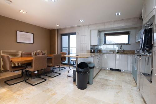 a kitchen with a table and chairs and a dining room at Stunning Swansea Marina beach house with sea views in Swansea