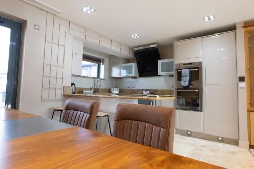 a kitchen with a table and chairs and a counter at Stunning Swansea Marina beach house with sea views in Swansea