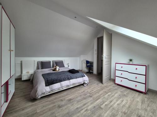 una camera bianca con un grande letto e un comò di Chez Roberto a La Chapelle-Saint-Mesmin