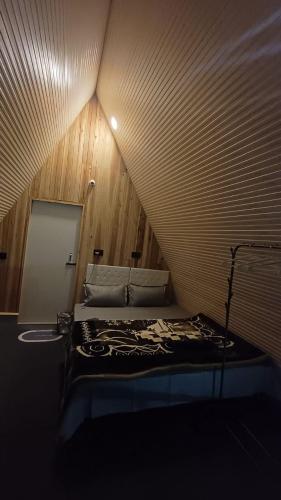 a small room with a bed in a attic at Cinchonna Farmstay in Darjeeling