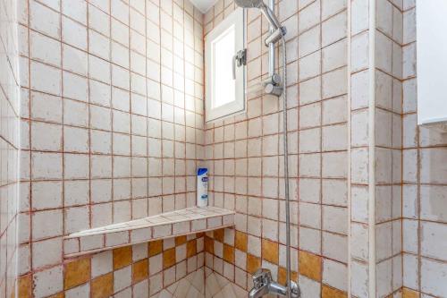 Un baño alicatado con ducha y ventana. en Cozy 1BD Apartment in Alonso Martínez, en Madrid