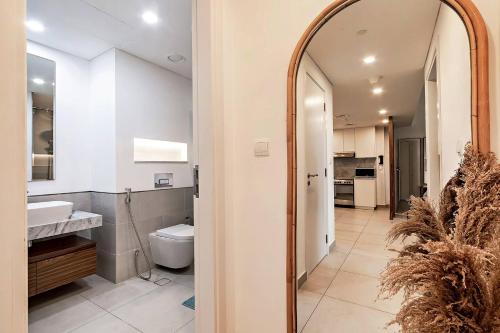 a bathroom with a mirror and a sink and a toilet at Modern 1BR Apartment Lamtara 3 in MJL in Dubai