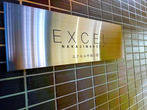 a sign on a tiled wall in a bathroom at Excel 中島公園 -FIX HOME- in Sapporo