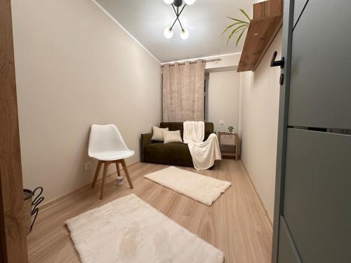 a living room with a couch and a chair at Mieszkanie w centrum miasta in Kętrzyn