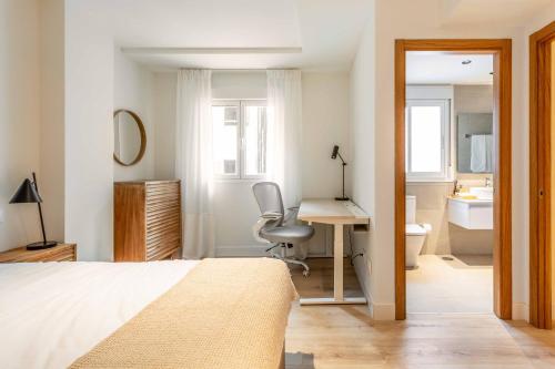 a bedroom with a bed and a desk and a bathroom at Modern Stay in Plaza Castilla in Madrid