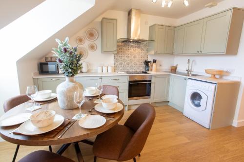 a kitchen with a wooden table with chairs and a dining room at Crucible House - 2-Bed Apartment in Stratford-upon-Avon
