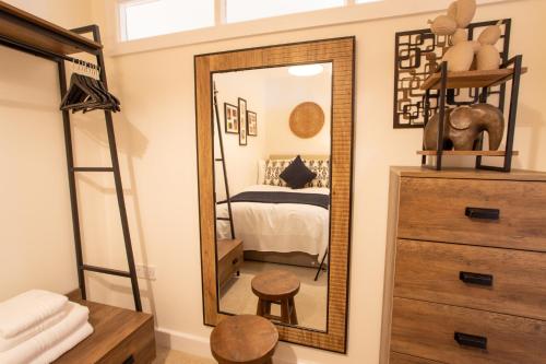 a bedroom with a mirror and a bed at Crucible House - 2-Bed Apartment in Stratford-upon-Avon