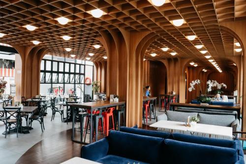 ein Restaurant mit Tischen und Stühlen und eine Bar in der Unterkunft The Bountie Hotel and Convention Centre Sukabumi in Sukabumi