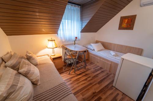 Una habitación con una cama y una mesa dentro. en Sárga Csikó vendégház, en Debrecen