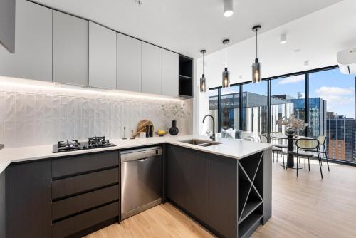 a kitchen with stainless steel appliances and a large window at City sky view self service apartment free parking in Adelaide