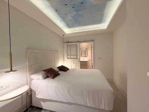 a bedroom with a white bed and a ceiling at Stylish Haven in Chic Salamanca in Madrid