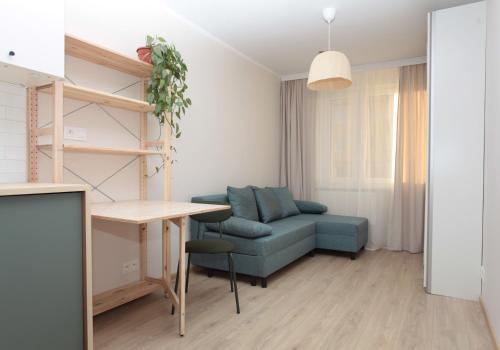 a living room with a blue couch and a table at Airport Friendly Studio in Bydgoszcz
