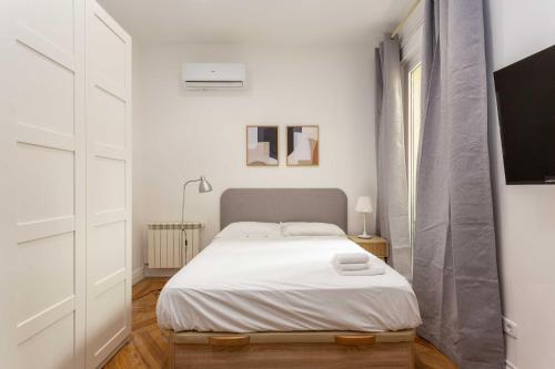 a bedroom with a bed in a white room at Urban Nest Retreat in Madrid