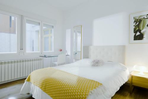 Un dormitorio con una cama con una manta amarilla y blanca. en Wonderful 2BR2BA flat overlooking Pedro Zerolo S, en Madrid